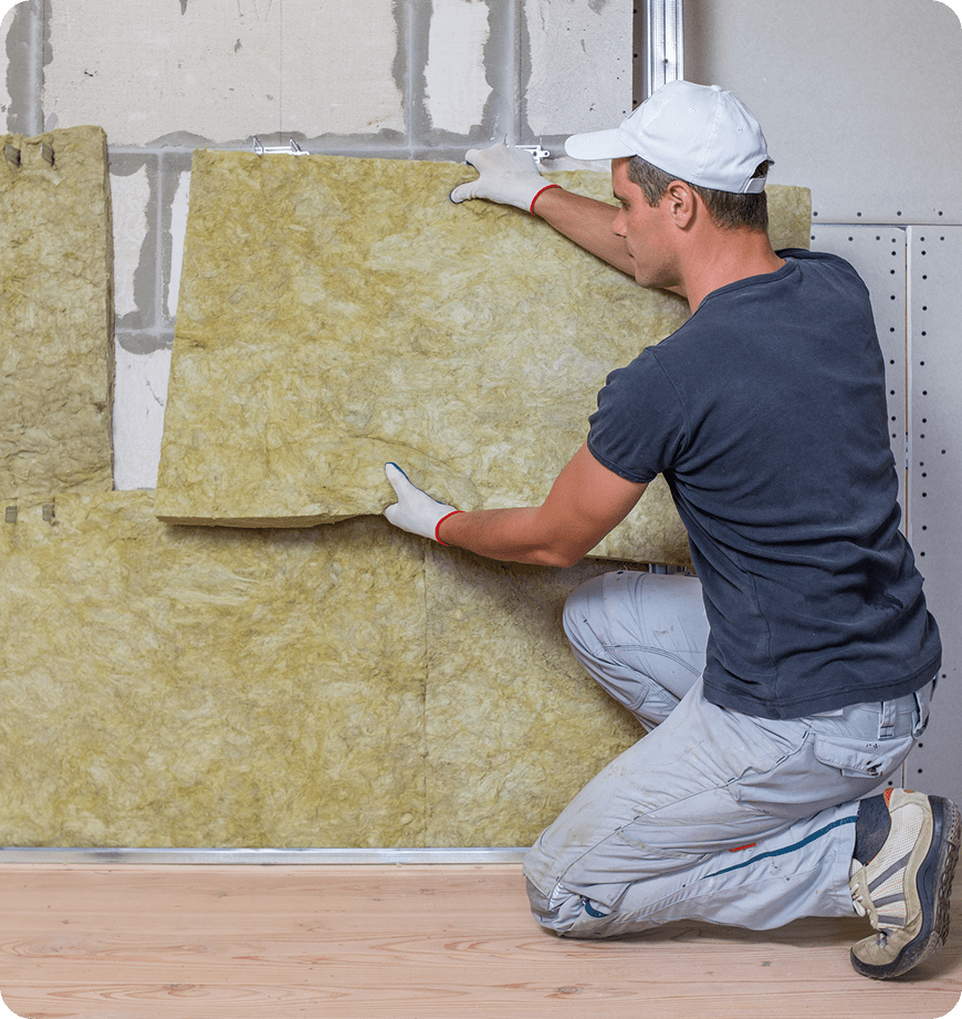 Professional contractor installing mineral wool insulation batts on a wall.