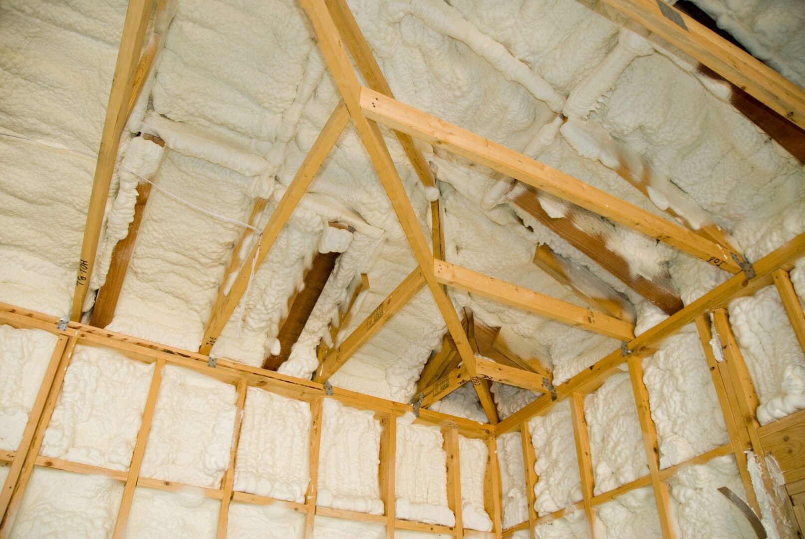 A room at a newly constructed home is sprayed with liquid insulating foam before the drywall is added.  Ideal for new home construction advertising and other ho