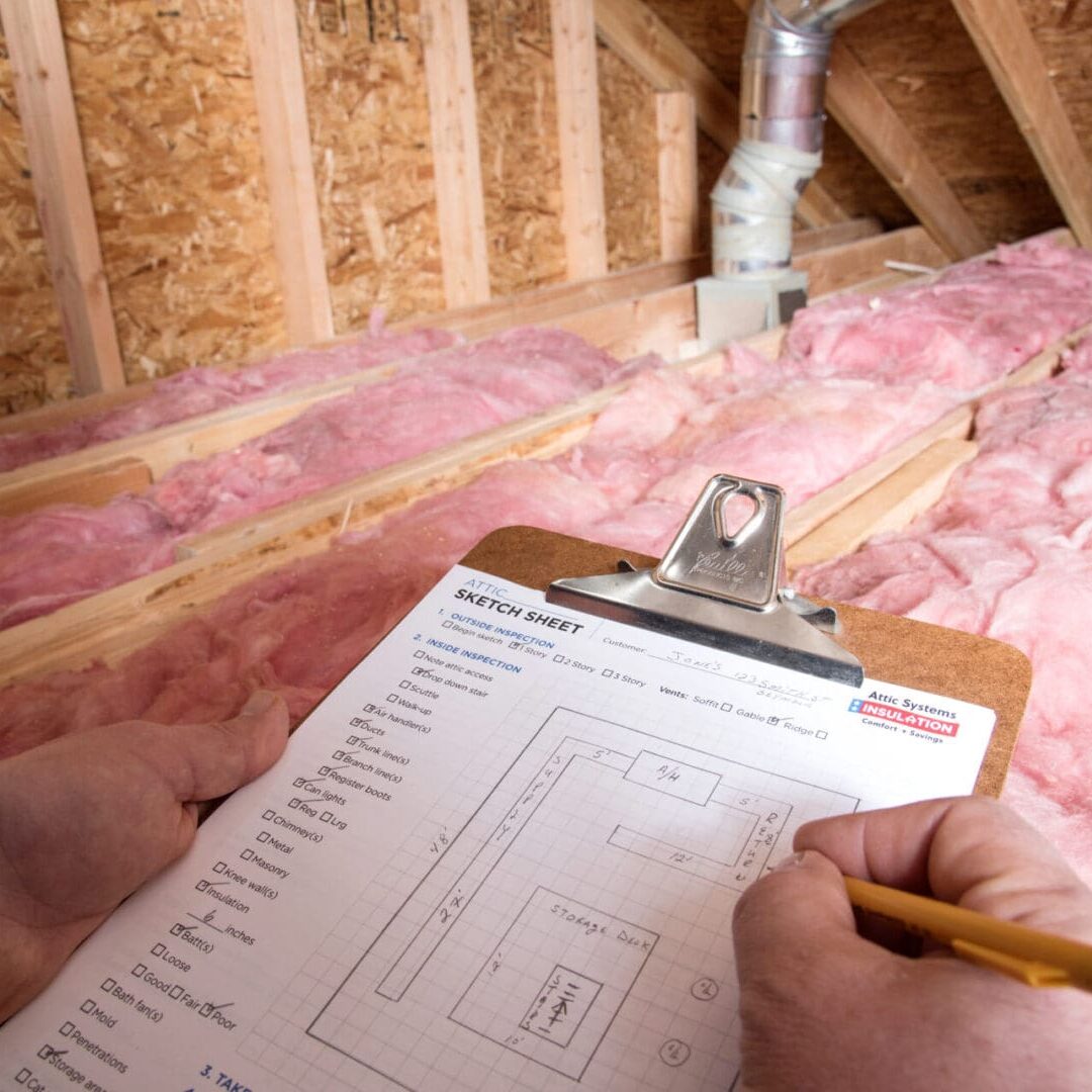 Inspecting attic insulation with clipboard notes.