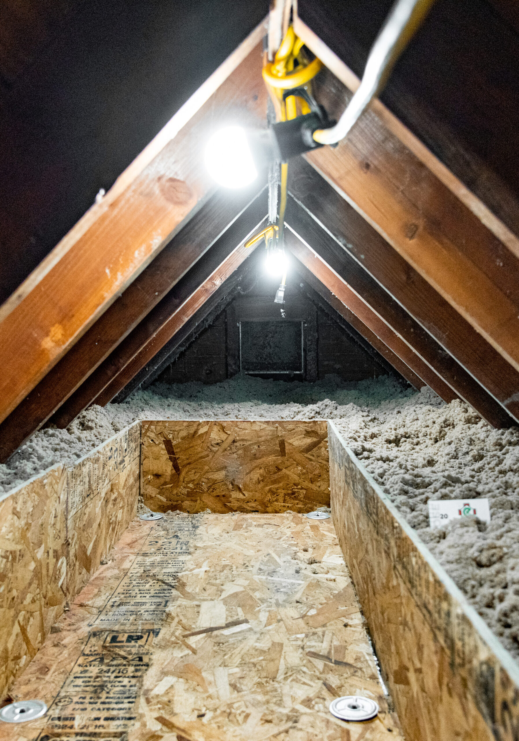 A well-lit attic being prepped for an attic insulation installation.